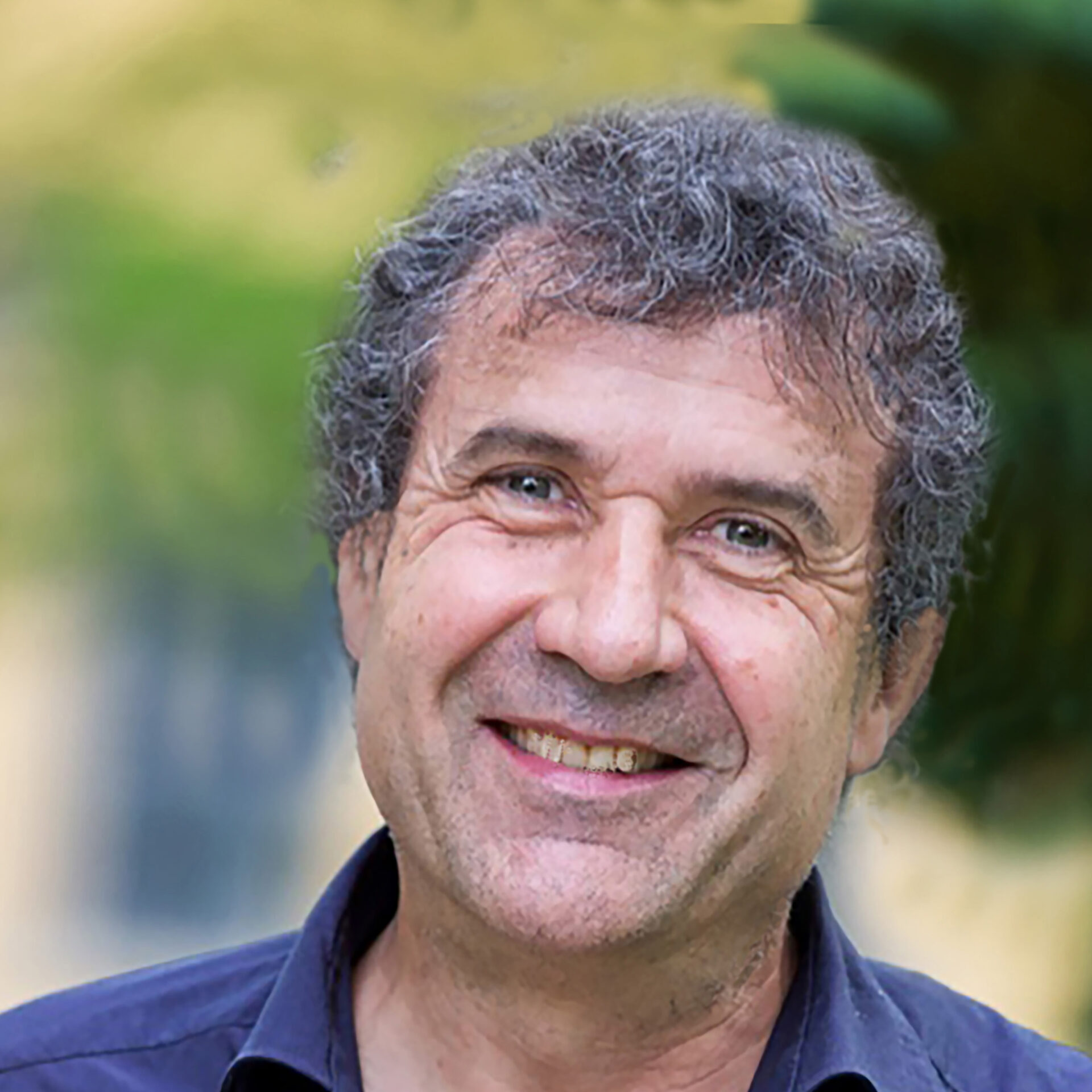 A small toy is standing in front of a pink background